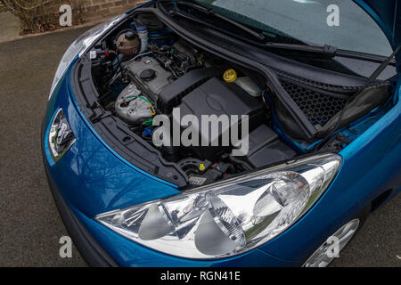 The open bonnet hood showing a Peugeot 207 car engine in England Stock Photo