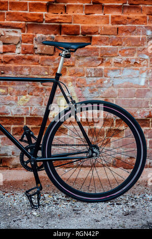 Detail of a customised commuter fixie bike at brick wall Stock Photo