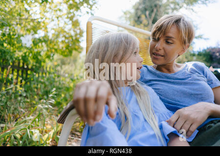 Mother and daughter relaxing in garden Stock Photo