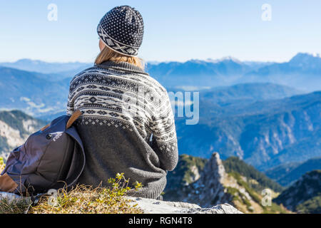 Germany, Garmisch-Partenkirchen, Alpspitze, Osterfelderkopf, female hiker on viewpoint looking at view Stock Photo