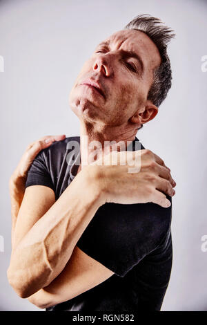 Portrait of egocentric mature man hugging hisself Stock Photo