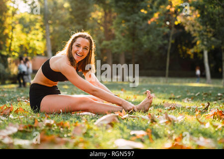 Fit young woman practicing yoga in a park Stock Photo