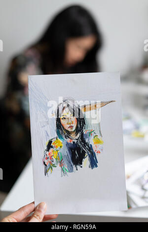 Woman's hand holding drawing of female portrait Stock Photo