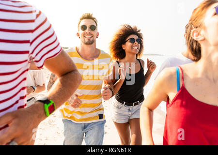 Friends having fun together, running on the beach Stock Photo