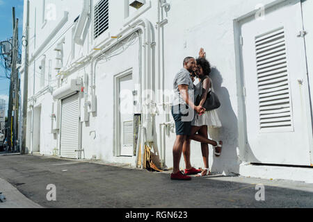 Smiling affectionate young couple standing at building Stock Photo