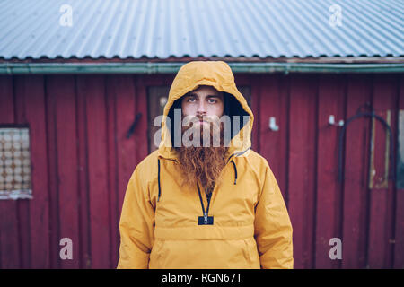 Sweden, Lapland, portrait of serious man with full beard wearing yellow windbreaker Stock Photo