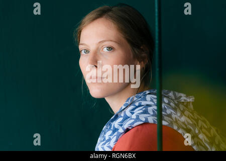 Portrait of young woman with dish towel above her shoulder Stock Photo
