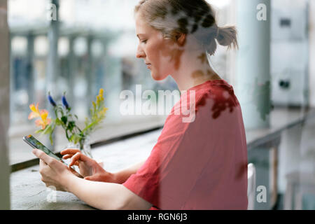 Young woman using tablet at the window in a cafe Stock Photo