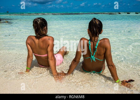 Carribean, Colombia, San Andres, El Acuario, rear view of two women sitting in shallow water Stock Photo