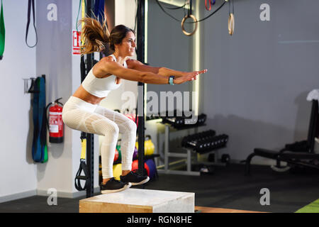 Man doing box jumps in a gym Stock Photo