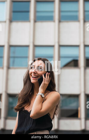 Portrait of smiling young woman on the phone Stock Photo