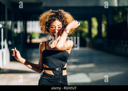 Portrait of young woman dancing outdoors Stock Photo