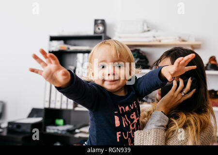 Portrait of a girl with mother at desk talking on cell phone Stock Photo