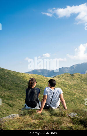 Bulgaria, Balkan Mountains, couple sitting on viewpoint, rear view Stock Photo