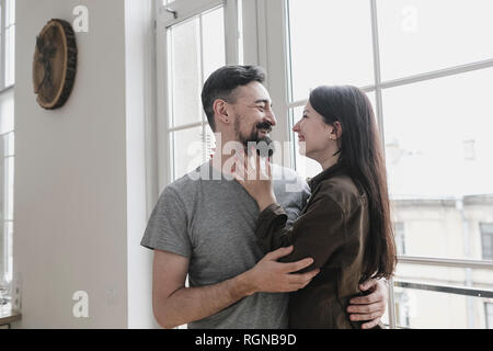 Happy couple embracing at home Stock Photo
