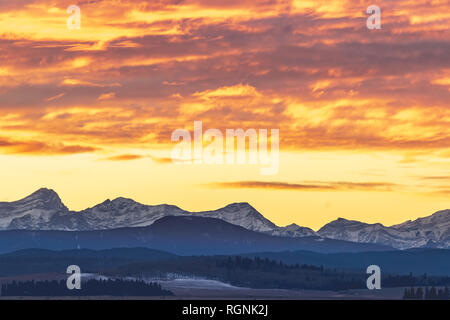 A winter sun sets in a beautiful blaze of colors over the foothills of the Canadian Rockies just outside the city of Calgary, Alberta. Stock Photo