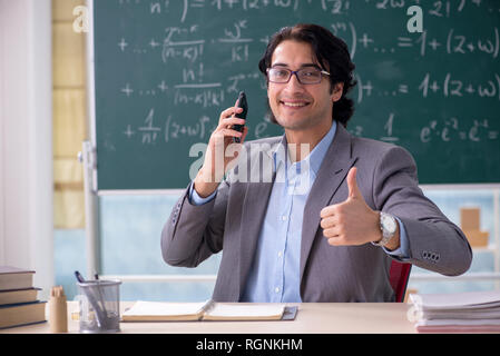 Young handsome math teacher in classroom Stock Photo