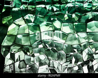 Close-up of a mosaic of retro style green colored, 3 dimensional looking glass cubicals glued to each other with light shining through Stock Photo
