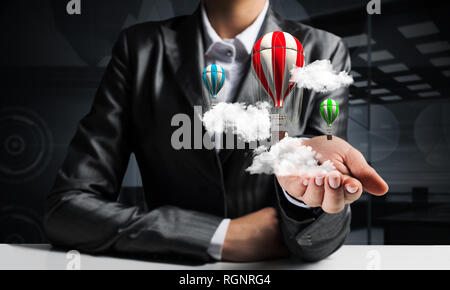 Woman presenting flying balloon in hand. Stock Photo