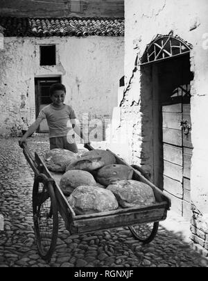 Italy, Basilicata, a child carrying the bread, 1950-60 Stock Photo