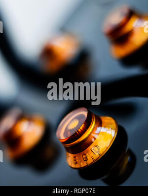 Close up on the volume and tone dials of an electric guitar - vertical Stock Photo