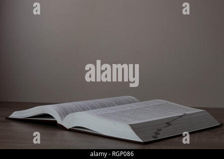One big book opened on the brown desk Stock Photo