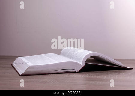 One big book opened on the brown desk Stock Photo