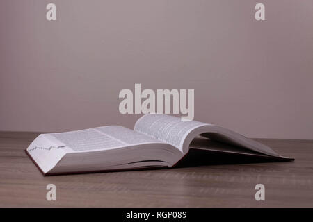 One big book opened on the brown desk Stock Photo