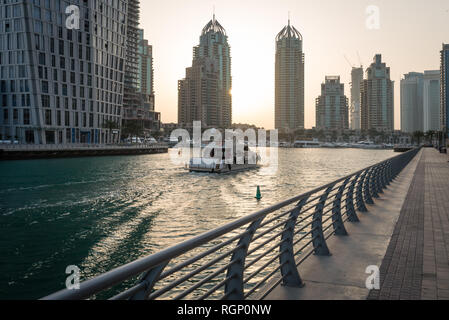 DUBAI, UAE - February 14, 2018: Boat entering Dubai Marina early in a morning. Dubai Marina is a district in the heart of what has become known as new Stock Photo