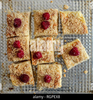 Sliced homemade cake with frozen raspberries on top, minimalistic style Stock Photo