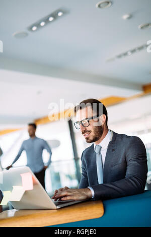 Young handsome architect working on laptop in office Stock Photo