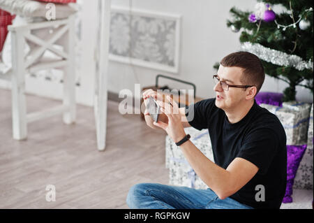Man at glasses recordering video on mobile phone. Streaming blog of blogger. Stock Photo