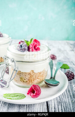 Recipe ideas for summer diet breakfast, healthy morning dessert Cheesecake in portioned jars with summer berries - raspberry, blueberry, blackberry. O