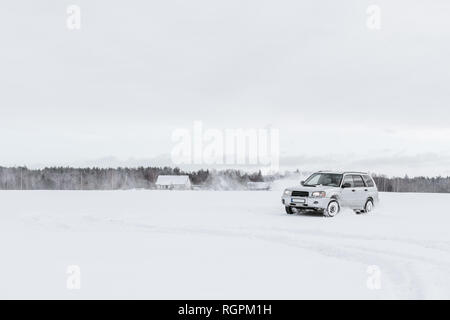Car driving on snow field Stock Photo
