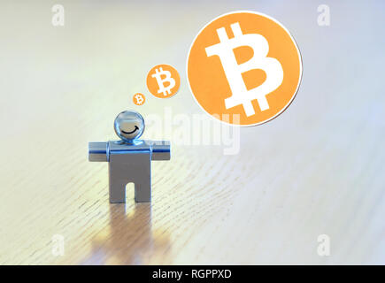 smiling figure with a bitcoin thought bubble Stock Photo