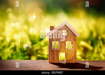 Wooden house on stone floor in front of nature background with bokeh