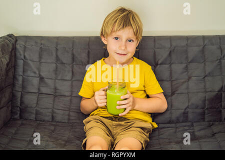 The boy is drinking Green tea latte with ice in mason jar. Homemade Iced Matcha Latte Tea with Milk zero waste