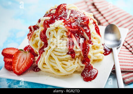 Spaghetti ice-cream with strawberry fruit sauce in close up view Stock Photo
