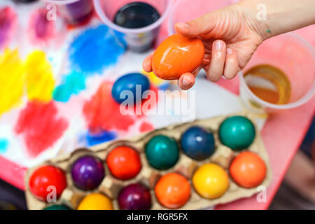 Child holding freshly boiled and colored Easter egg in his hand Stock Photo