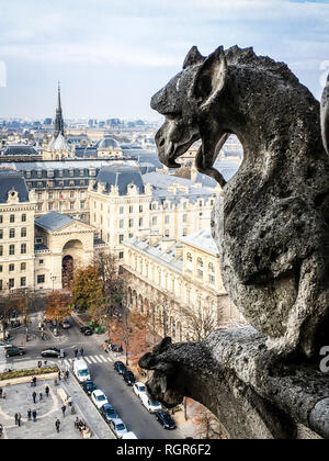 One of the famous chimera statues of Notre-Dame de Paris cathedral, gazing at the city from the towers gallery. Stock Photo