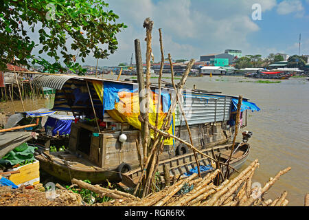 Can Tho, Vietnam - December 30th 2017. A house boat moored in Can Tho. The final boats of the day at the Can Tho floating market can be seen behind Stock Photo