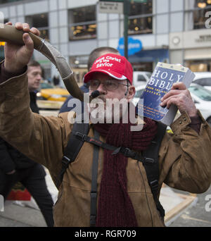 Fundamentalist Christian group of mostly Korean people march in  Manhattan encouraging people to take Jesus into their hearts so they don't go to Hell. Man blows ram's horn. Stock Photo