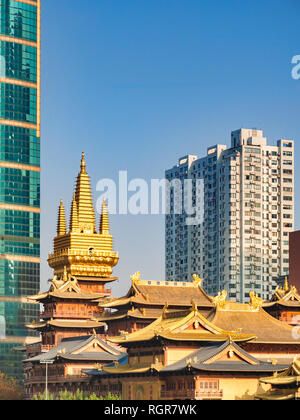 Jing'an Buddhist Temple in Shanghai, China, surrounded by modern high-rise buildings. Stock Photo