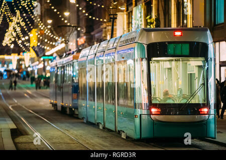 Helsinki, Finland. Tram Departs From Stop On Aleksanterinkatu Street. Night Evening Christmas Xmas New Year Festive Street Illumination. Beautiful Dec Stock Photo