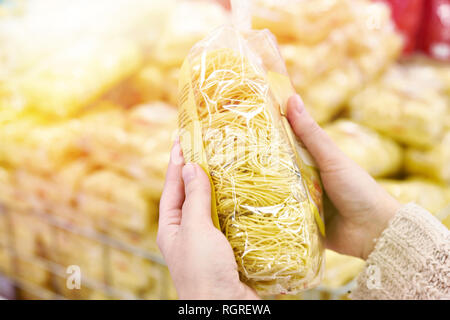 Pack of spaghetti in the hands of the buyer at the store Stock Photo