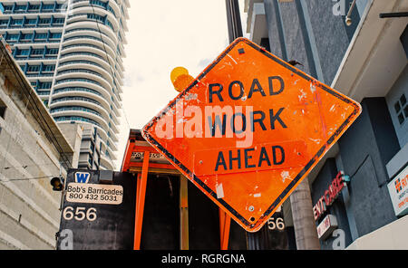 Miami, USA - October 30, 2015: construction sign on city road. Road work ahead warning and safety. Transportation traffic and travel. Caution and warn concept. Stock Photo