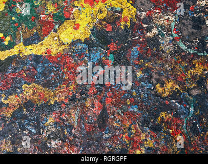Spots of paint red, yellow, blue and other colors are randomly spilled on concrete and form an abstract background Stock Photo