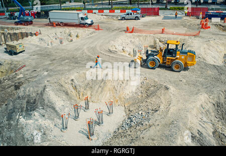 Miami, USA - October 30, 2015: workers and machinery on construction pit. Building site works on sunny outdoor. Construction and building activity. Development and engineering concept. Stock Photo
