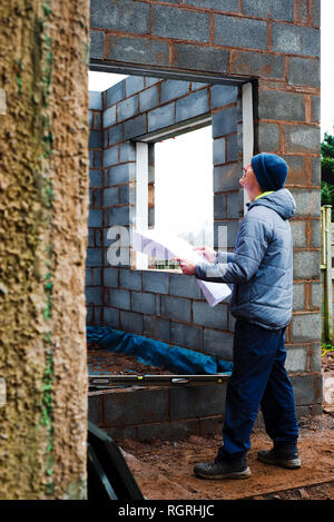 Builder working on home extension project built with block cavity walls. Stock Photo