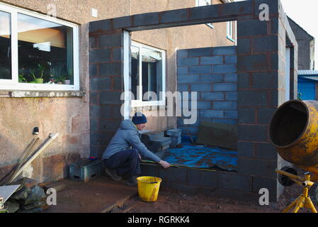 Builder working on home extension project built with block cavity walls. Stock Photo